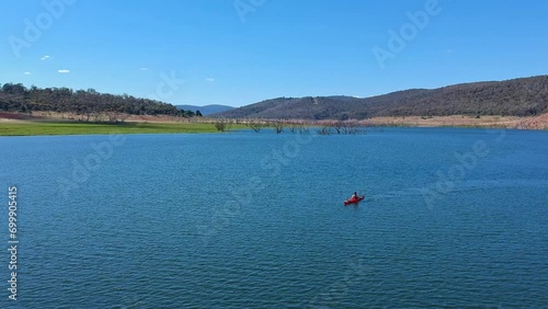 Kayaker quietly paddling across Lake Eucumbene in the Snowy Mountains of NSW Australia photo