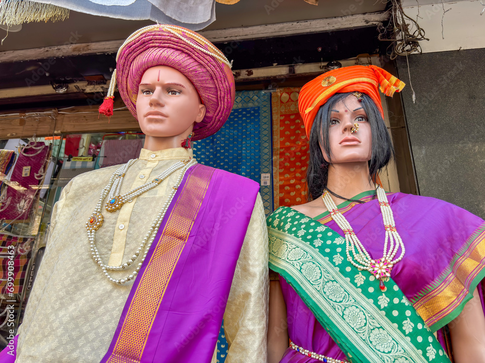 A dummy statue of couple displayed wearing traditional kurta, sari hat with jewellery