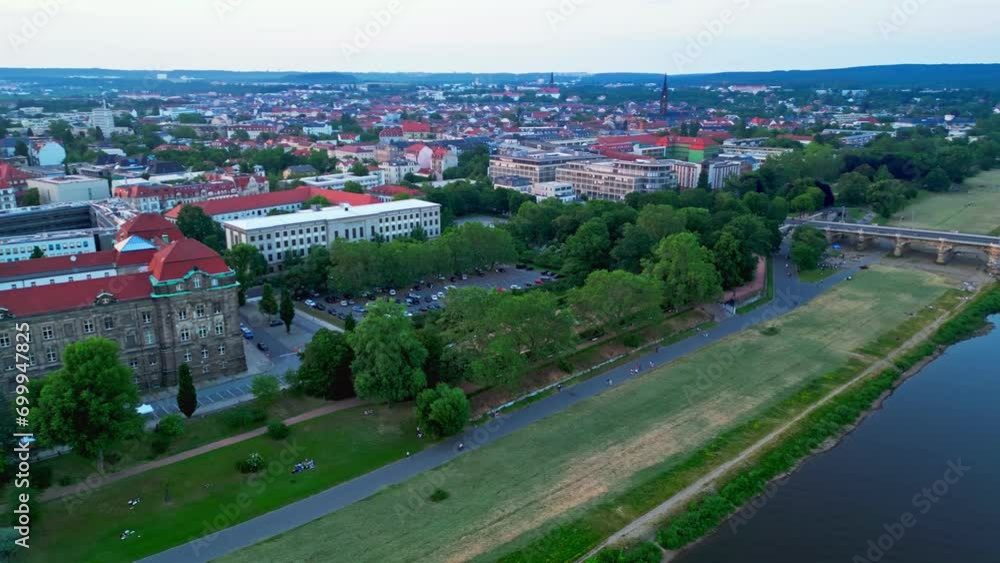 Panoramic aerial view of Dresden, a capital city in Germany, featuring a bridge, river, historic buildings, and city traffic, all along tree lined streets Panoramic aerial view of Dresden, a capital city in Germany, featuring a bridge, river, historic buildings, and city traffic, all along tree lined streets