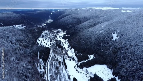Aerial view of mountain road with snow-capped forests and valley during winter in Hautes-Vosges, France photo