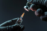 a hand in a medical glove draws liquid from an ampoule from a syringe with a needle