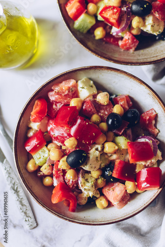 Healthy rich protein Greek salad with tomatoes, bell pepper, cucumber, black olives, feta cheese, onion and chickpeas