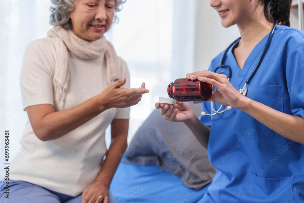 Obraz premium Health check concept, Elderly Asian woman with grey hair, sitting and talking to young Asian nurse by appointment, sitting on medical bed.