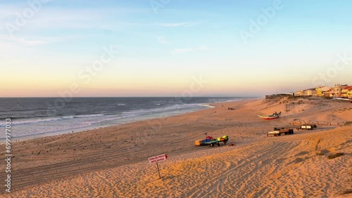Pristine sandy coastline washed by the Atlantic Ocean during golden hours in Pedrogao beach, Portugal. photo
