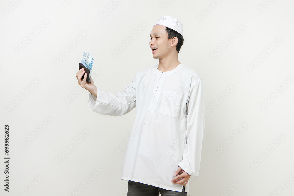 muslim man holding money rupiah banknotes in the wallet. People religious Islam lifestyle concept. celebration Ramadan and ied Mubarak. on isolated background. muslim man holding money rupiah banknotes in the wallet. People religious Islam lifestyle concept. celebration Ramadan and ied Mubarak. on isolated background.
