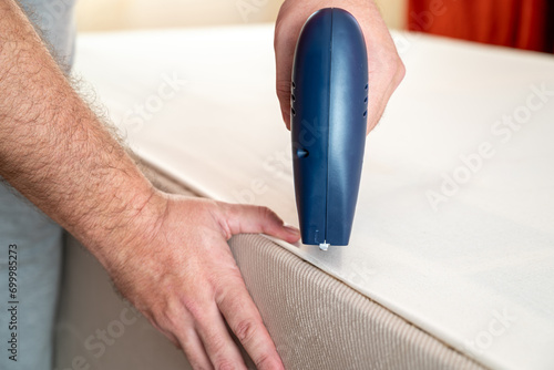 Worker stapling sofa lining with electric staple gun photo