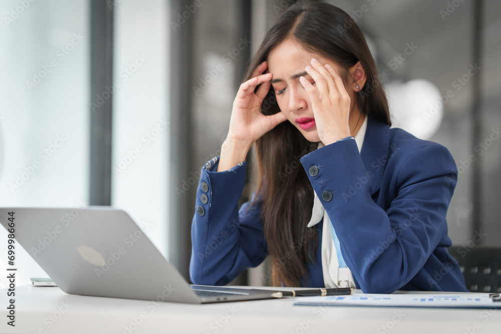 stressed young businesswoman with a credit card in hand, looking worried in front of her laptop. stressed young businesswoman with a credit card in hand, looking worried in front of her laptop.