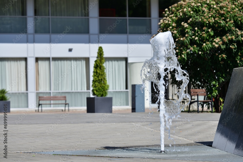 The high-flowing city fountain on the square in the city