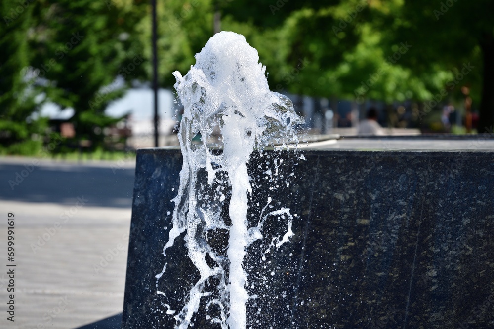 Spa splashing fountain on the stone square for guests