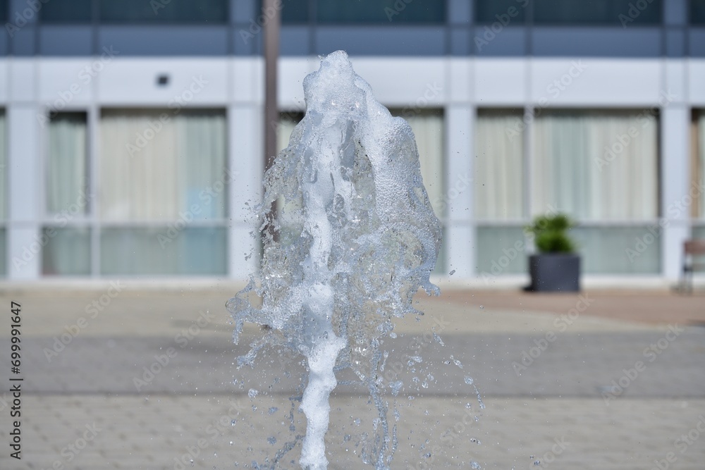 The high-flowing city fountain on the square in the city