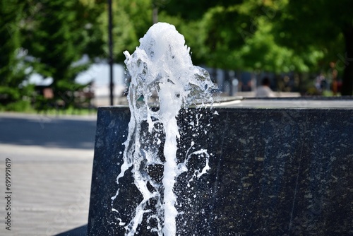 Spa splashing fountain on the stone square for guests