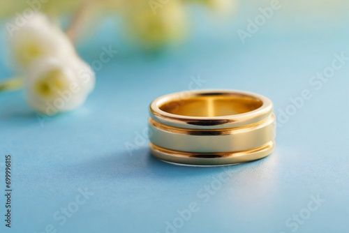 Gold ring on a light blue pastel background