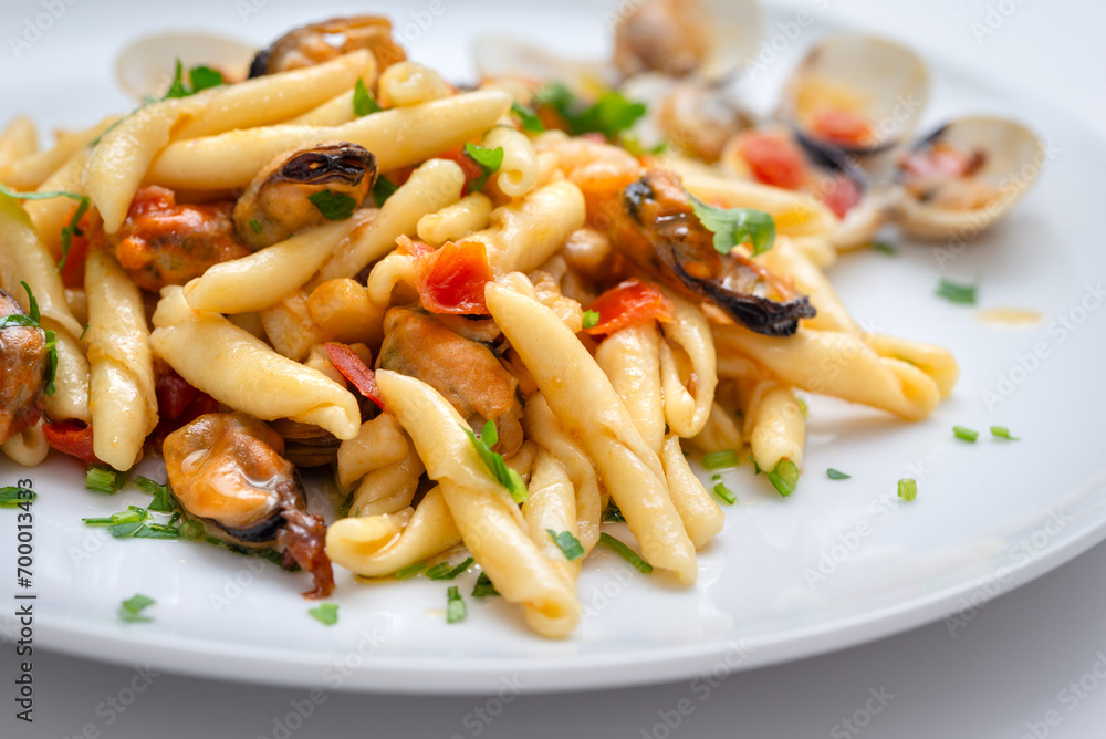 Piatto di deliziose trofie caserecce condite con salsa ai frutti di mare, cibo italiano Piatto di deliziose trofie caserecce condite con salsa ai frutti di mare, cibo italiano