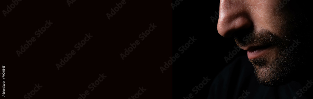 Obraz premium Bearded man bend down the head in dark room Guy looks down on black background with side view Concept serious depression and dismal Alone businessman close eyes and hopeless depressed He get lonely