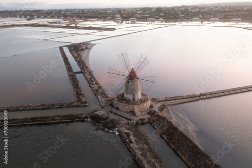 Sunset at Windmills in the salt evoporation pond in Marsala, Sicily island, Italy Trapani salt flats and old windmill in Sicily. View in beautifull sunny day. © Michal