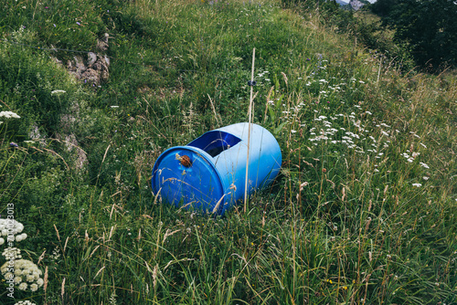 Old blue drum converted into a rainwater tank in the field. Concept of sustainability  recycling and environment
