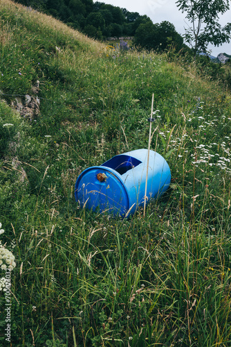 Blue bucket converted into a rainwater tank in the field. Concept of sustainability, recycling and environment