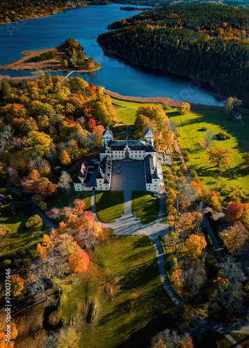 Aerial view on the beautiful palace in sweden. Autumn sunset. Bogesunds Slott. White palace in the autumn forest. High altitude.