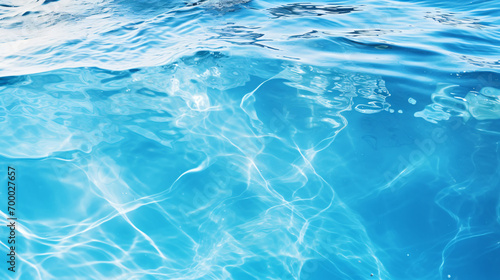 Clear blue water surface with splashing ripples. #700027657