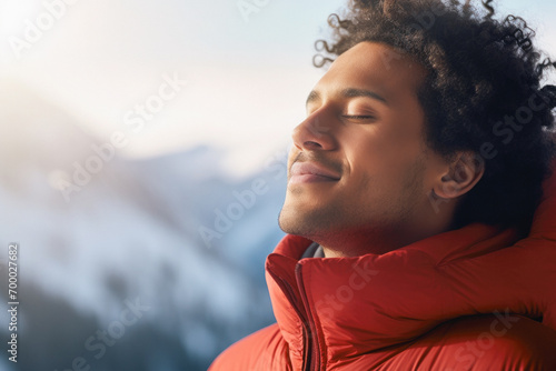 portrait of a man in the rays of the sun on a sunny winter day in the mountains