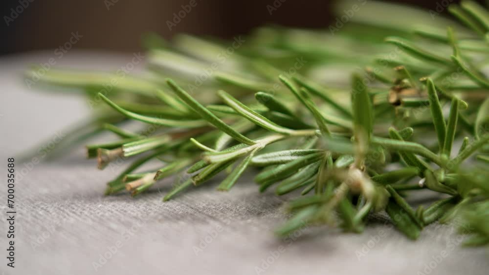 Fresh rosemary twigs on a kitchen table. Aromatic green spice close up. Rotation Fresh rosemary twigs on a kitchen table. Aromatic green spice close up. Rotation