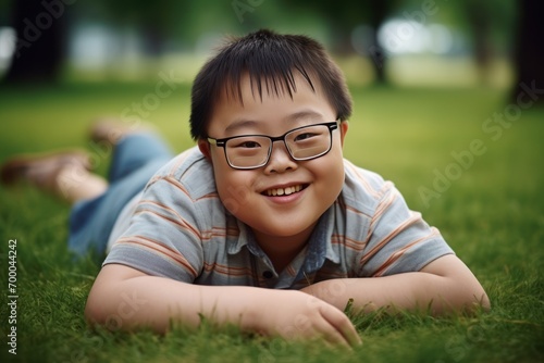 a child asian with down syndrome walks in the park and smiles at the camera