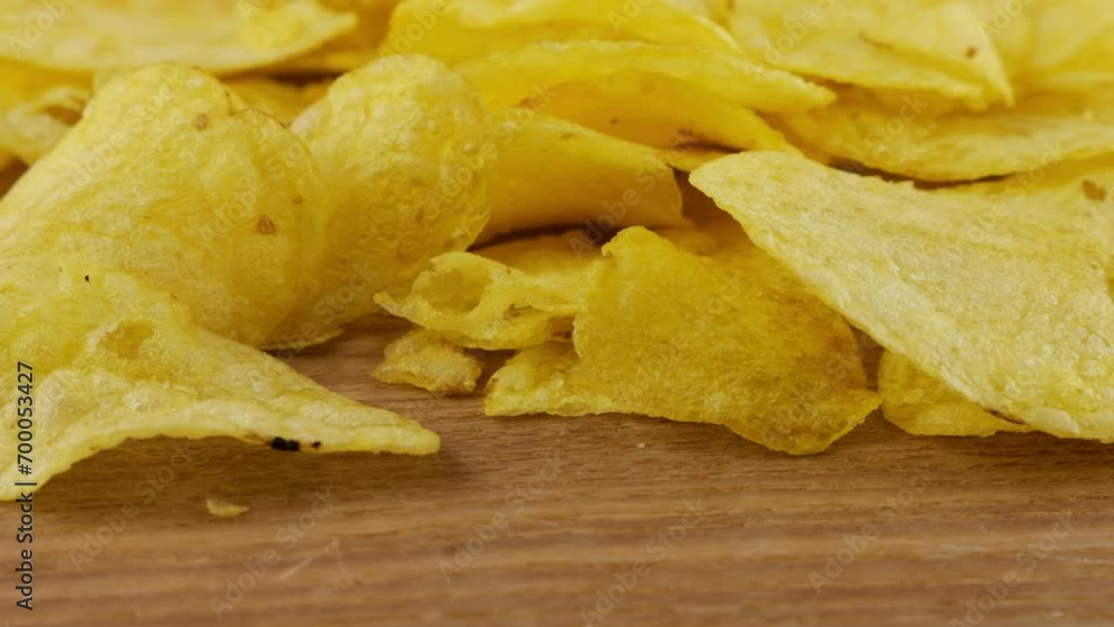 Potato chips rotating on a wooden board.