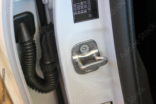 Front door latch on the middle pillar of a white vehicle