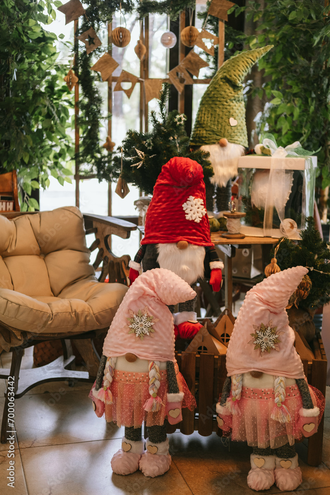 Obraz premium Cute Christmas gnomes or dwarfs in the room with other festive decorations.