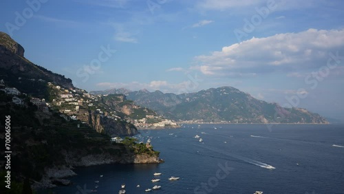 Panoramic view of tourist destination on Amalfi Coast, view of Amalfi cliff side port. Big mountains in background .Famous tourist resort. Boats and yachts riding on sea. Shooting in slow motion. photo