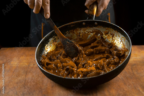 The cook prepares meat with vegetables and onion in a bowl . Oriental cuisine