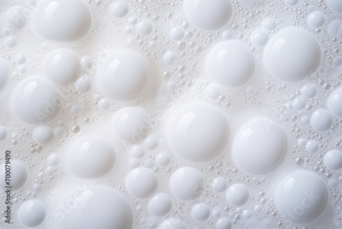 White foam bubbles on abstract background caused by detergent.