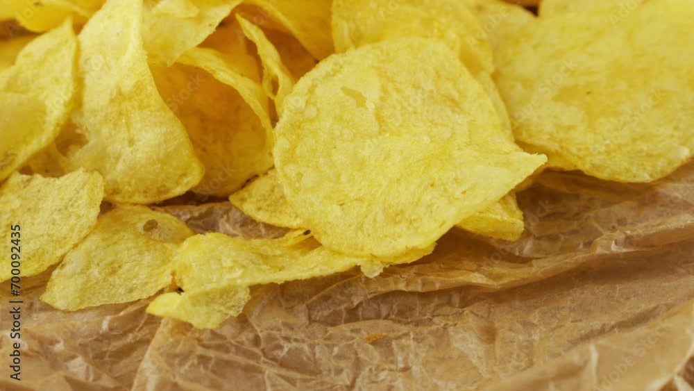 Potato chips rotating close up on culinary parchment. Potato chips rotating close up on culinary parchment.
