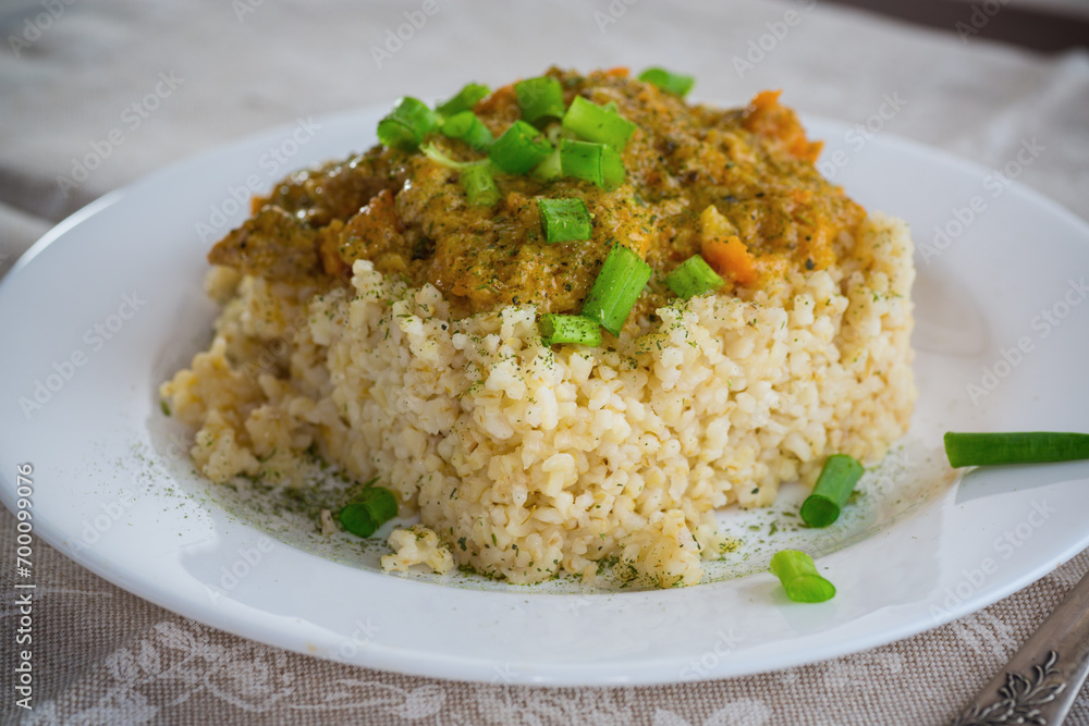 cooked bulgur with meat sauce and vegetables in a plate cooked bulgur with meat sauce and vegetables in a plate