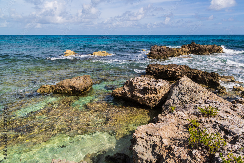 Tropical sea, rocks, cliffs and turquoise Caribbean Sea, Playa del Norte beach in Isla Mujeres, Mexico