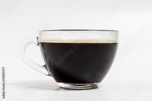 Black coffee in a glass mug on a white background, aromatic coffee for energy