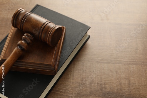 Law concept. Gavel and book on wooden table, closeup. Space for text