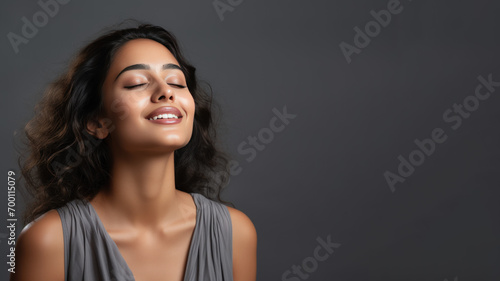 A Indian woman breathing calmly looking up isolated on gray background photo