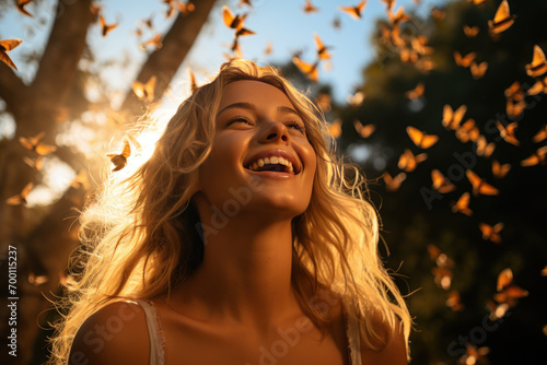 Happy blonde woman excited looking up in the butterflies