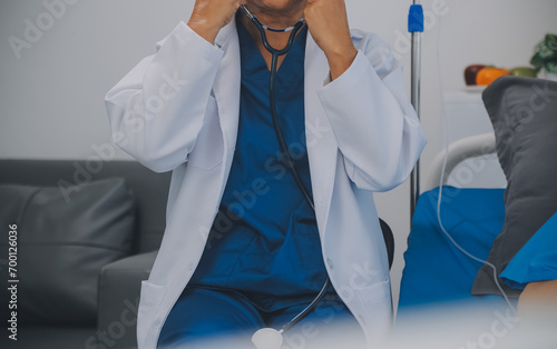 Asian Doctor make routine health check with patient in hospital ward photo