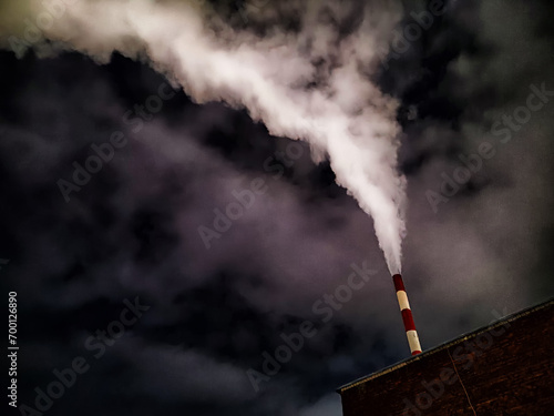 Winter night industrial landscape. Coal-fired power station with smoking chimneys against dramatic dark sky. Air pollution. Carbon dioxide CO2 emissions as primary driver of global climate change