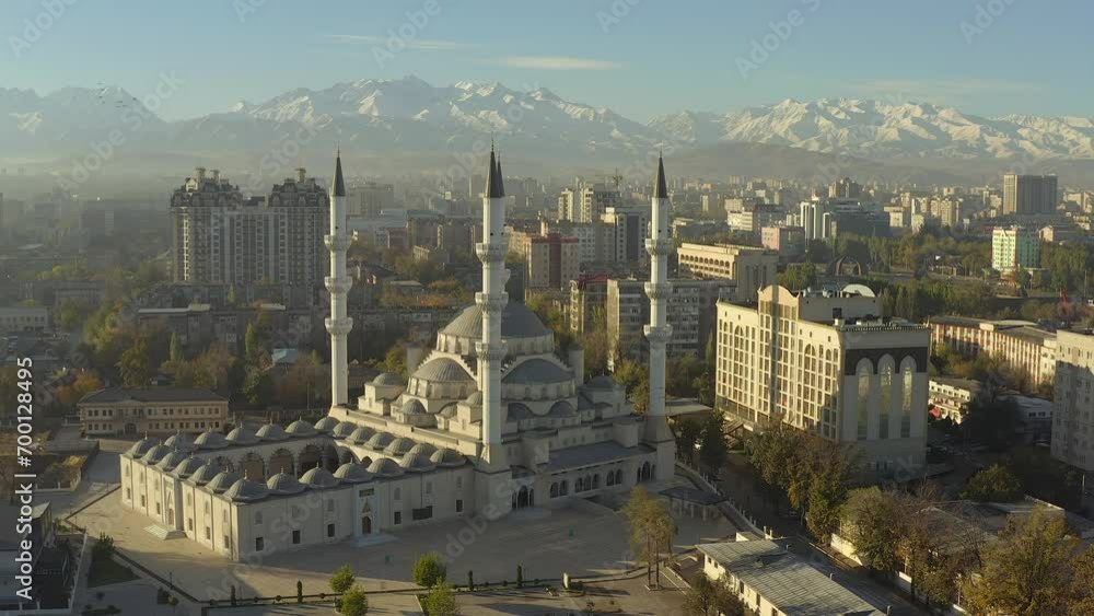 The Central mosque named after Imam Al Sarakhsi against the background of the snow-capped mountains of Kyrgyzstan. A circular flyby. The main attraction of Bishkek.