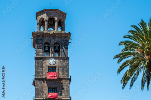 The tower of the historic church Iglesia de la Concepci  n in San Crist  bal de La Laguna on Tenerife  against a deep blue summers sky