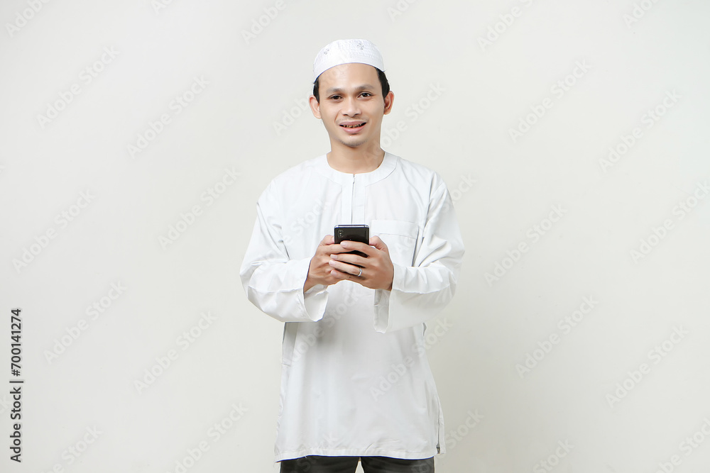happy muslim man holding mobile phone. People religious Islam lifestyle concept. celebration Ramadan and ied Mubarak. on isolated background.