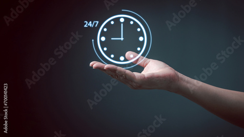 Nonstop service 24 hr concept. Man hand holding virtual 24-7 with clock on hand for worldwide nonstop and full-time available contact of service concept. Assistance customer services.