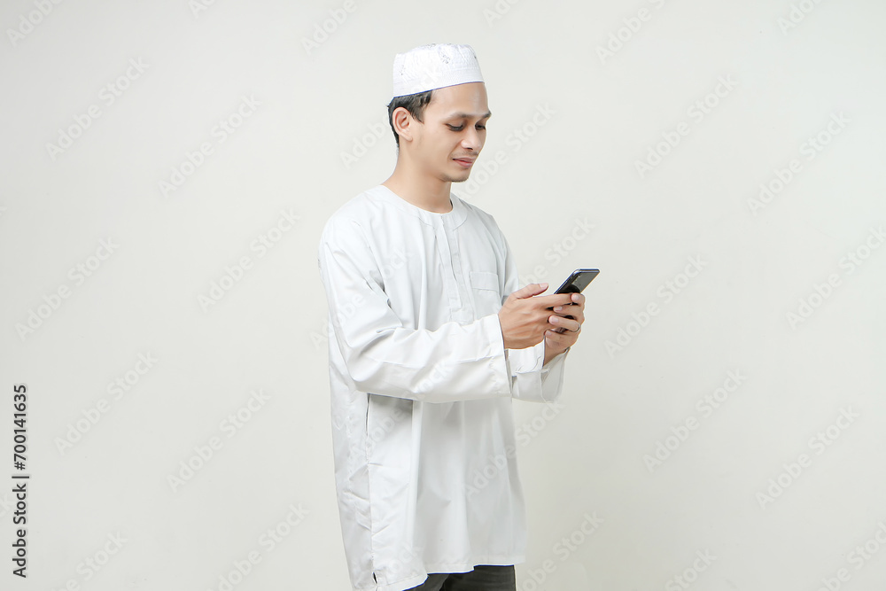 happy muslim man holding mobile phone. People religious Islam lifestyle concept. celebration Ramadan and ied Mubarak. on isolated background. happy muslim man holding mobile phone. People religious Islam lifestyle concept. celebration Ramadan and ied Mubarak. on isolated background.