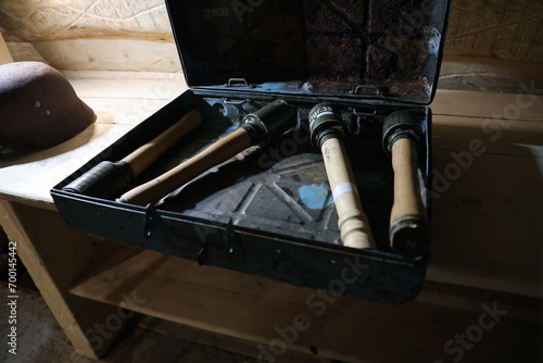 World War II german fragmentation grenades stacked in a military box on wooden table in dark interior