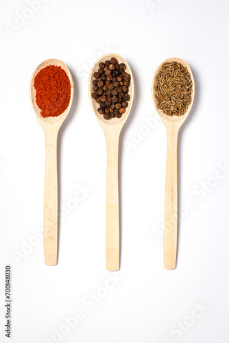Wooden spoon with spices on a white background