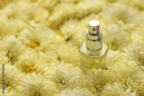 Women fragrance perfume bottle with flowers background close up. Unnamed blank sprayer bottle of perfume for women photo