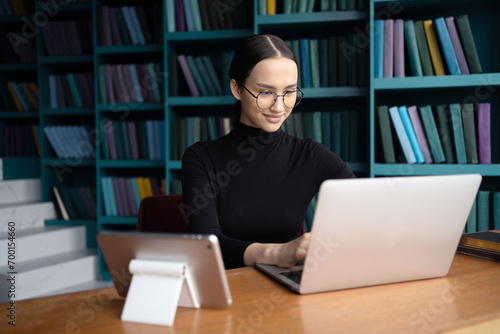 A freelance copywriter working online uses a laptop in a coworking space.